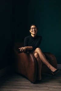 Smiling asian woman sitting on an armchair