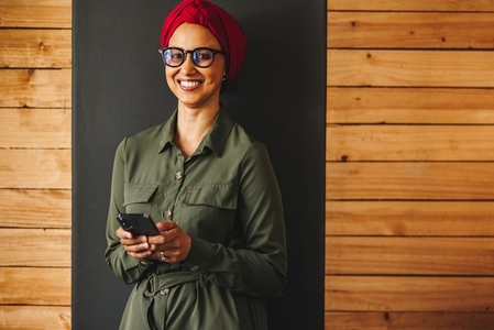 Happy Muslim businesswoman using a smartphone in an office