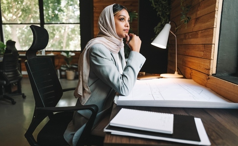 Thoughtful Muslim achitect working in a coworking space