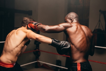 Two boxers fighting in a boxing ring