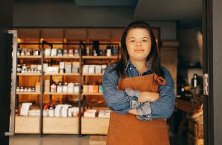 Confident woman with Down syndrome standing in front of a grocery store