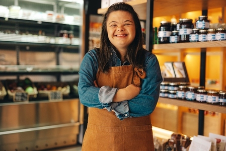 Shop worker with Down syndrome smiling at the camera