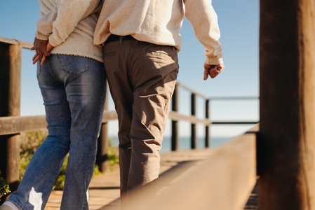 Mature couple walking along a foot bridge at the beach
