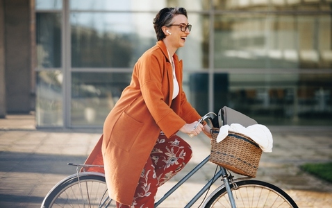 Cheerful business woman riding a bike to work in the city