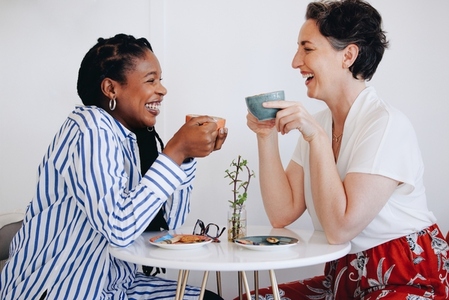 Happy businesswomen having coffee together in an office cafe
