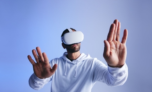 Curious young man touching virtual space with his hands