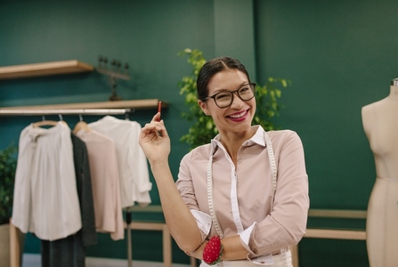 Smiling seamstress standing at her workshop