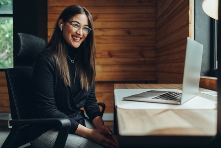 Happy young businesswoman working in a coworking space