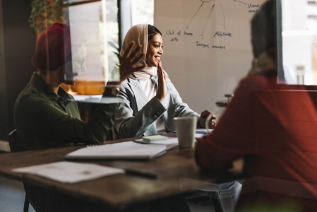 Happy Muslim businesswomen having a virtual meeting in an office
