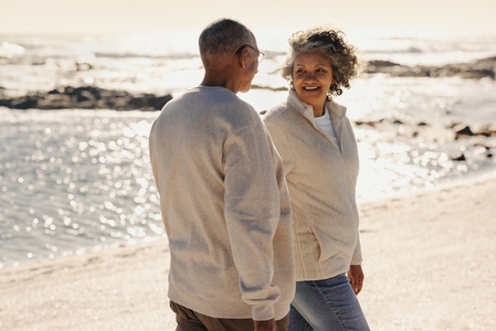 Cheerful senior couple walking together along the beach
