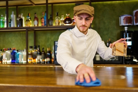 Bartender cleaning counter in a nice pub
