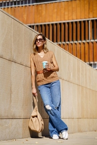 Stylish female with coffee on street
