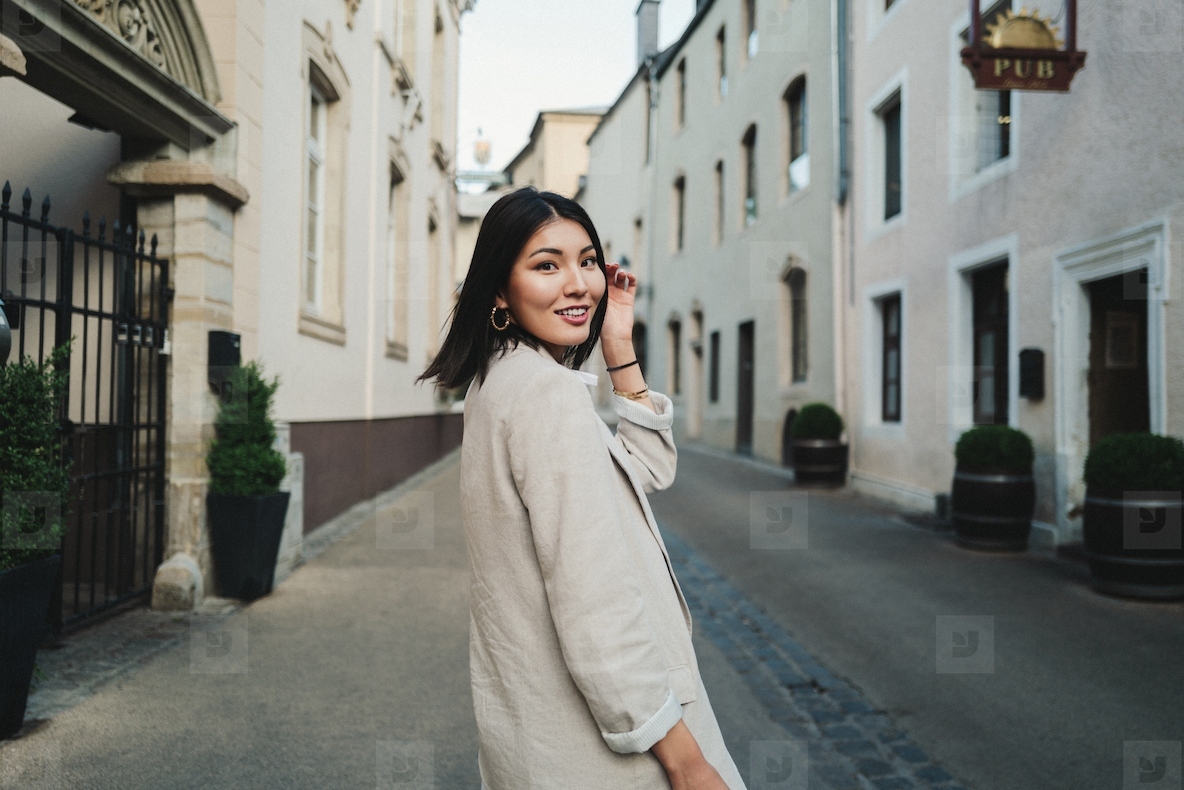 Asian woman walking through a street in a European city