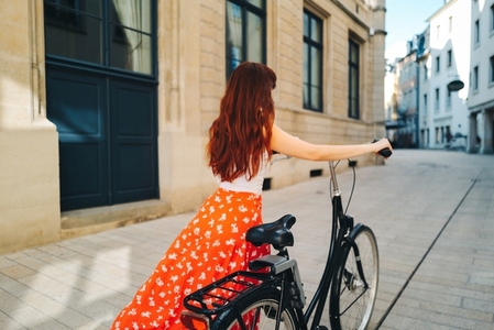 Female traveller exploring a city with a bicycle