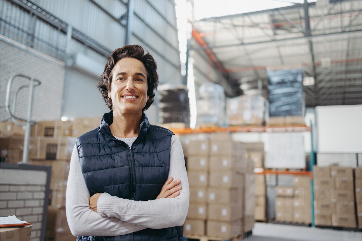 Portrait of a mature woman smiling at the camera in a distribution warehouse