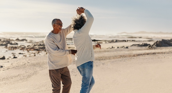 Elderly couple dancing at the beach