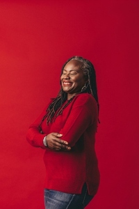 Carefree woman with dreadlocks smiling happily in a studio