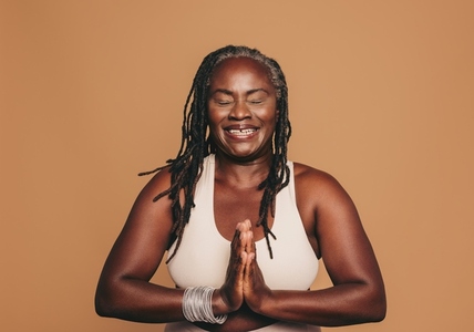 Happy black woman meditating in a studio