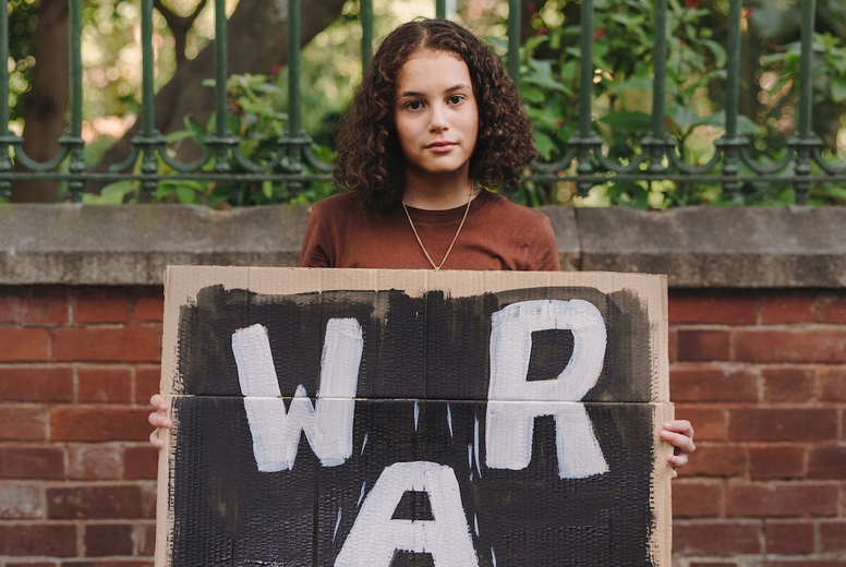 Teenage activist holding an anti-war poster