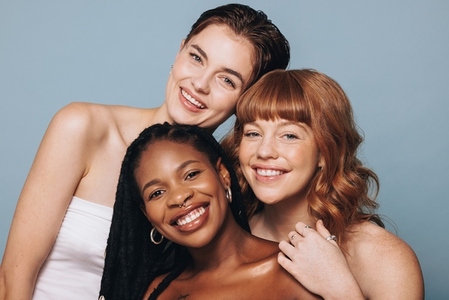 Portrait of women with different skin tones smiling at the camera