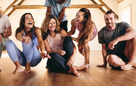 Group of happy people having fun together in a yoga studio