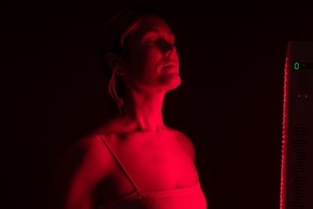 Woman getting red light therapy from a red light device