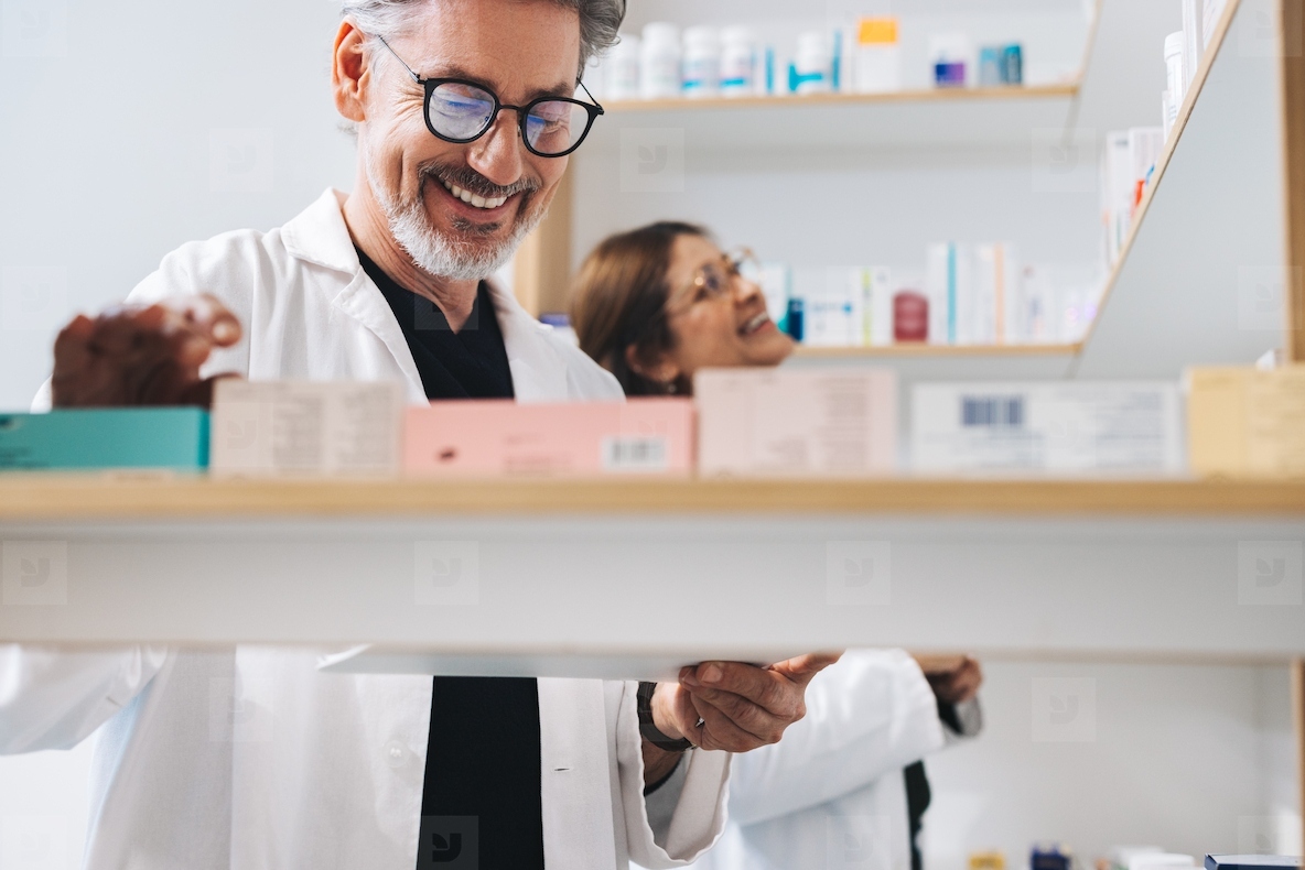 Male pharmacist picking prescription medication in a drug store