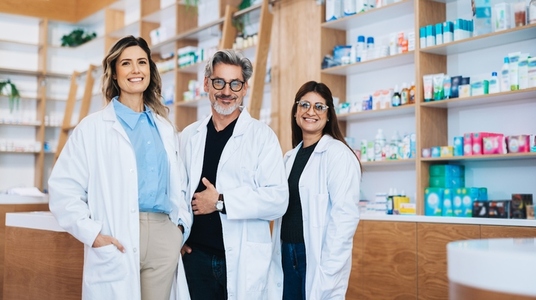 Three pharmacists standing together in a drug store