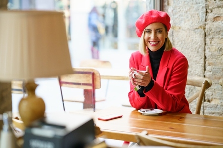 Cheerful woman with coffee in cafe