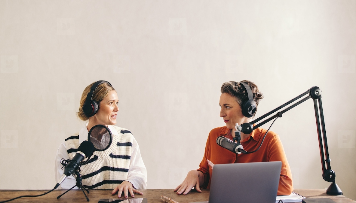 Two female podcasters having a conversation on their show