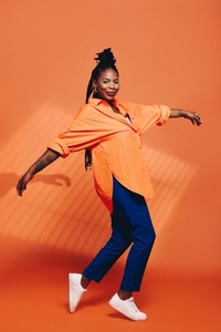 Fashionable black woman dancing in casual clothing in a studio