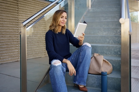 Woman reading e book on steps