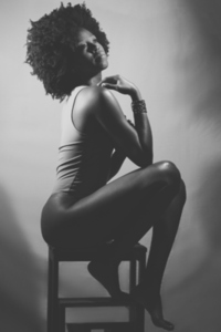 Black and white photograph of sensual black woman under neon light