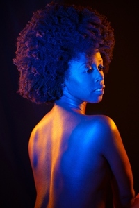 Naked black woman under neon light