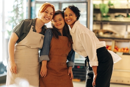 Cheerful retail workers smiling at the camera in a grocery store