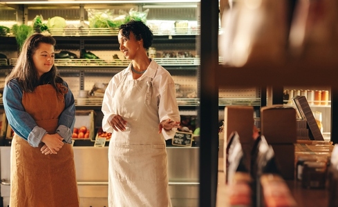 Mature grocery store manager giving instructions to her new employee