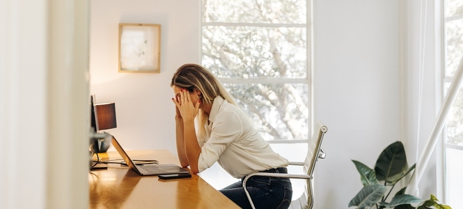 Overworked businesswoman having a headache in her office