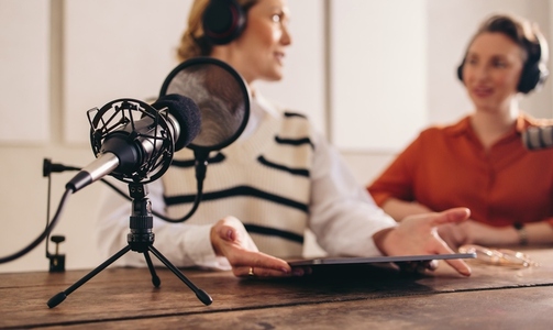 Two women recording a podcast in a home studio