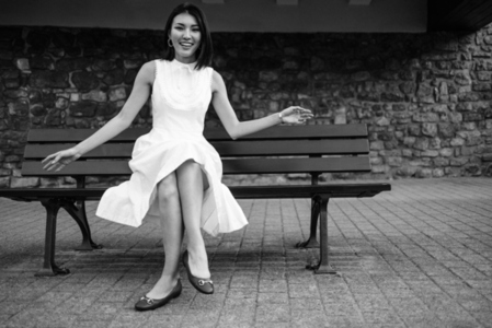 Asian woman sitting on an urban bench