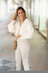 Smiling woman with sunglasses in beige outfit