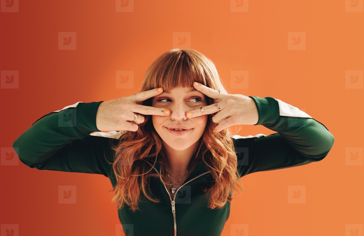 Woman making v signs with her hands in a studio