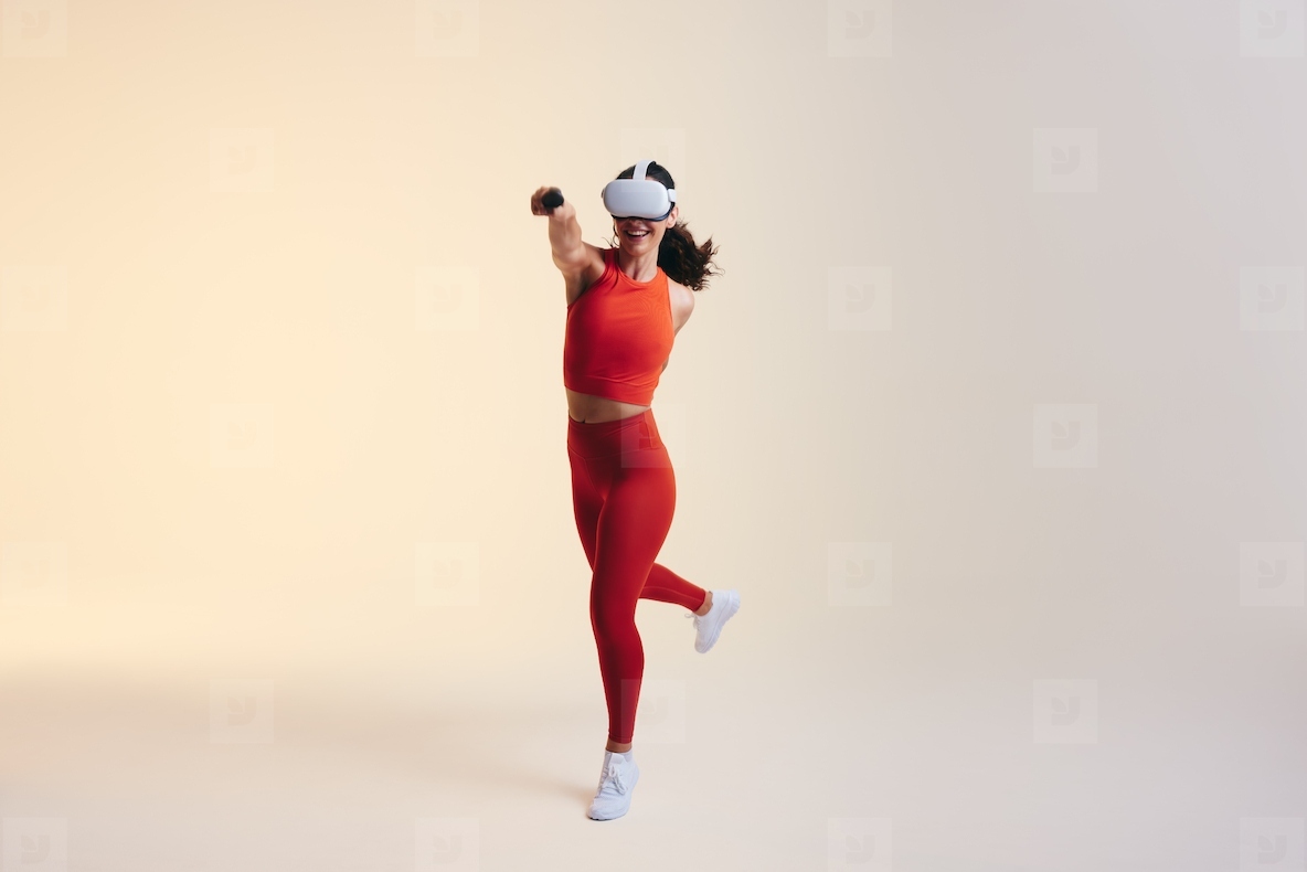 Happy young woman having fun in a virtual reality fitness game
