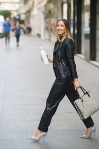 Modern trendy female with reusable bottle in downtown