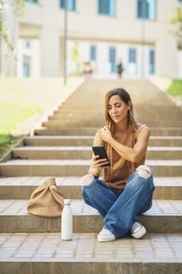 Female with smartphone sitting on stairs