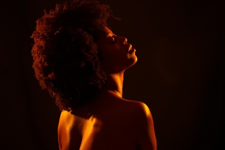 Nude African American female under orange light