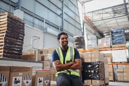 Warehouse employee smiling happily in a large logistics centre