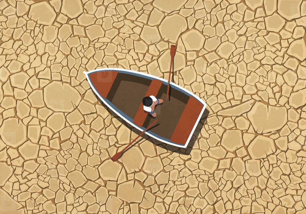 Man sitting in rowboat on dry