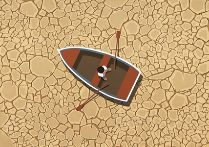Man sitting in rowboat on dry