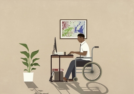 Man in wheelchair working at computer in home office