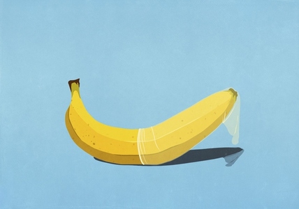 Condom on yellow banana against blue background